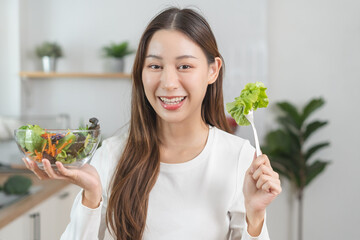 Wall Mural - Diet, Dieting asian young woman or girl use fork at lettuce on mix vegetables, green salad bowl, eat  food is low fat good health. Nutritionist female, Weight loss for healthy person.