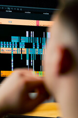 Close-up of man's head behind the monitor screen editing software is included, editing story dashboard, professional software for cinema and advertising