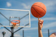 © muse studio - A close-up of a basketball player spinning a ball on their finger, with the hoop blurred in the background.