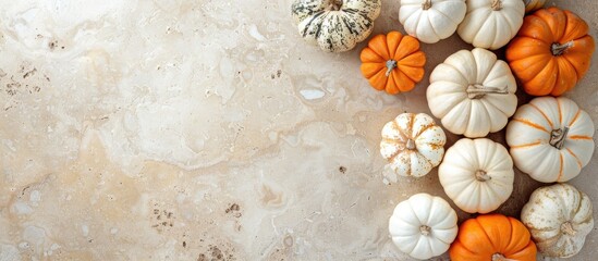 Poster - Top view of orange and white pumpkins on a stone surface with a clear area in the middle for Thanksgiving and Halloween advertisements in a copy space image