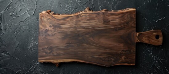 Leinwandbilder - Handmade walnut wood cutting board displayed on a black surface with copy space image