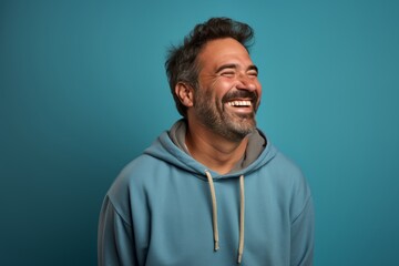 Poster - Portrait of a grinning man in his 40s wearing a zip-up fleece hoodie on pastel blue background