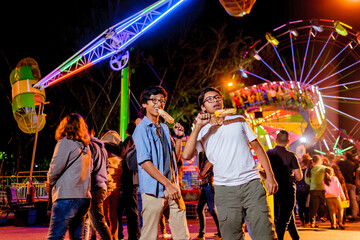 Two young people visit the amusement park and enjoy the experience