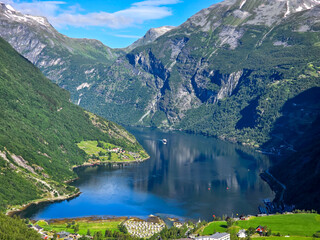 Wall Mural - Serene Fjord Reflection Near Geiranger, Norway Under Clear Blue Skies