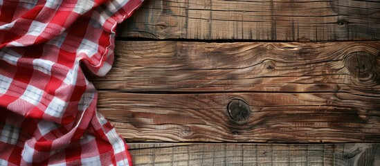 Poster - Red checkered napkin or tablecloth on raw wooden table showing planks and texture with available copy space image