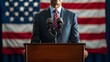 © TigerDude - A man in a suit standing behind a podium with microphones. A front view with a blurred American flag in the background.