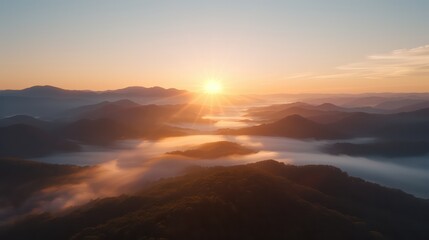 Aufkleber - The sun is setting over a mountain range, casting a warm glow over the landscape. The sky is filled with clouds, creating a sense of calm and serenity. The mountains are covered in trees