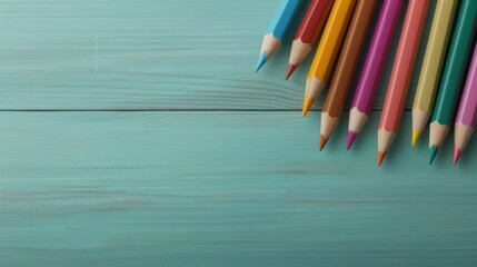 Aufkleber - A row of colored pencils on a wooden surface. The pencils are arranged in a line, with the blue pencil on the far left and the red pencil on the far right