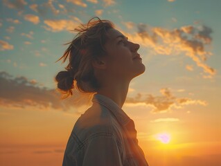 Canvas Print - Silhouetted figure gazing with hopeful expression towards the glowing sunset horizon