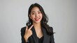 © somneuk - Happy young Asian business woman in blazer pointing finger up isolated on white background