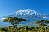 A picturesque view of the Mount Kilimanjaro in Tanzania, with its snowcapped peak against a clear blue sky