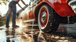 © Mirjana - Person washing a classic car in the driveway during late afternoon sunshine
