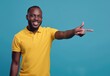 © Cetin - happy man in yellow polo pointing to the side with hand on light blue background