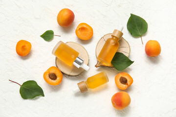 Wall Mural - Bottles of cosmetic oil with fresh apricots on white background