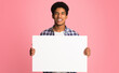 © Prostock-studio - Happy guy showing blank placard with copy space for your text, pink background