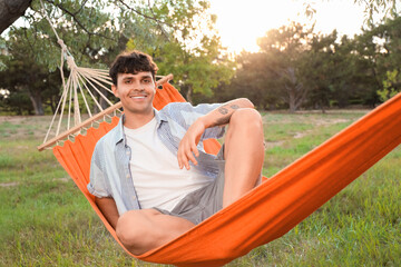 Wall Mural - Young man resting in hammock outdoors