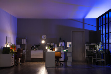 Sticker - Interior of dark office with desks, shelf units and glowing lamps