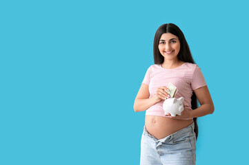 Canvas Print - Young pregnant woman putting money into piggy bank on blue background. Maternal Benefit concept