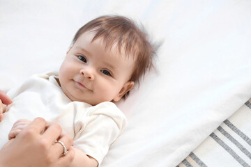 Sticker - Cute little baby with mother lying on bed, closeup