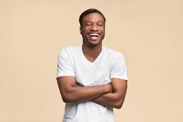 Poster - Laughter. Positive Black Man Laughing Crossing Hands Looking At Camera Standing On Yellow Background. Studio Shot