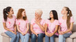 © Prostock-studio - Breast Cancer Survivors. Diverse Women In Pink T-Shirts Sharing Treatment Experience Sitting On Sofa Indoor.