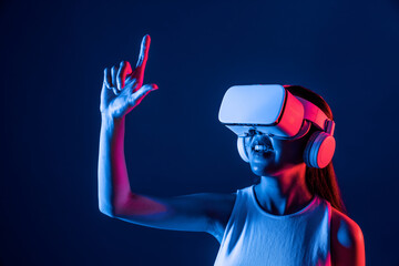 Female standing surrounded by neon light wear VR headset connecting metaverse, futuristic cyberspace community technology, spreading index and thumb finger interacting virtual object. Hallucination.