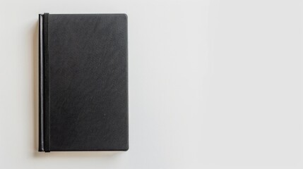 Sticker - A single black covered notebook on a white background