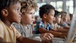 © svastix - Young children in a classroom setting, each engaged with their laptops, showcasing the integration of technology in education and fostering learning and concentration.