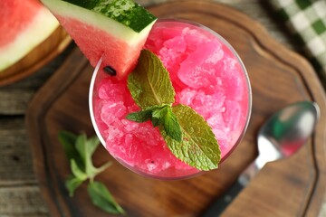 Wall Mural - Tasty watermelon sorbet in glass dessert bowl, fresh fruit, mint and spoon on table, top view