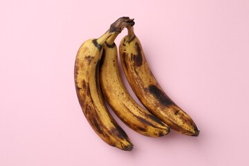 Wall Mural - Bunch of ripe bananas with dark spots on pink background, top view