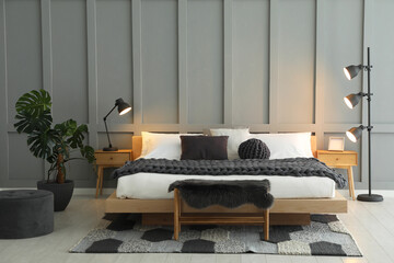 Sticker - Stylish bedroom interior with comfortable bed, lamps and houseplant