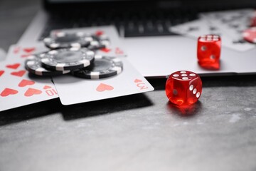 Poster - Poker chips, laptop, playing cards and dices on grey table, closeup. Online game