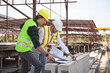 © JU.STOCKER - Engineers in hardhats discussing on construction site, Engineer and foreman worker team with blueprints checking project at the precast concrete factory site