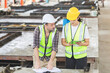 © JU.STOCKER - Engineer and female foreman worker with blueprints and digital tablet checking project at the precast concrete factory site, Engineer team in hardhats discussing on construction site