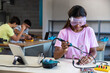 © Daniel - Teen African American female high school student in electronics class working on a project alone. Copy space.