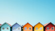 © Steven - Vibrantly colored houses with red, yellow, blue, and orange exteriors stand in a row against a clear blue sky.