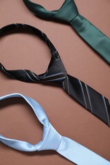 Wall Mural - Three necktie on brown background, flat lay