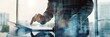 © ffunn - Double exposure of businessman using tablet in modern city with double exposure of cityscape and sunlight. Concept of modern business. Toned image