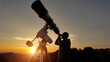 © astrosystem - Amateur astronomer looking at the evening skies, observing planets, stars, Moon and other celestial objects with a telescope just before sun down.