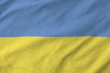 Wall Mural - Ukraine flag depicted on folded wavy fabric of old cloth close up