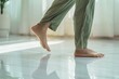 © Marina Demidiuk - Close up focus on young female feet walking barefoot on clean tile floor at home. Young woman standing on warm floor indoors, underfloor heating concept. Woman's legs in bathroom. Floor heating