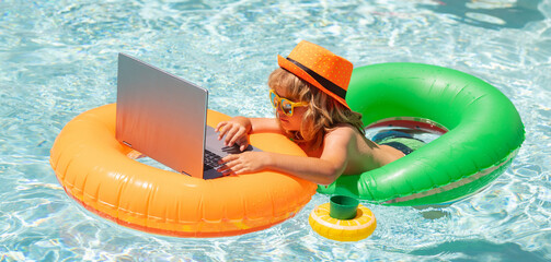 Little freelancer, business man on summer travel. Kids working with laptop on summer vacation holidays. Little freelancer using computer, remote working in swimming pool.