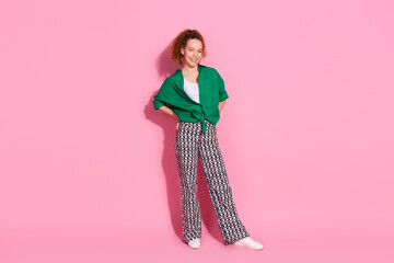 Poster - Full length photo of adorable lovely girl wear green shirt smiling walking empty space isolated pink color background