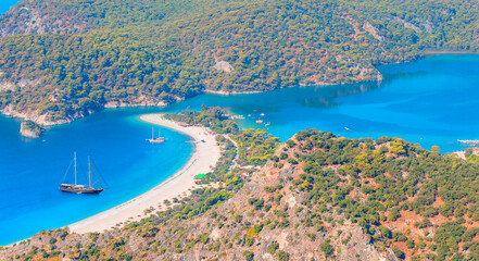 Wall Mural - Blue gulet anchored with rainbow at the Aegean sea - Panoramic view of Oludeniz Beach And Blue Lagoon, Oludeniz (Ölüdeniz) beach is best beaches in Turkey - Fethiye, Turkey