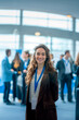 © GustavsMD - Smiling young woman with conference badge in a professional networking event. Indoor event photography. Business and networking concept for design and print