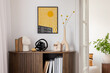 © FollowTheFlow - Stylish interior with a wooden cabinet plants, decorative objects, and books. A vibrant mock up art piece featuring a sunburst design adds a pop of color. Minimalist home decor. Template.