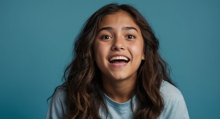 Poster - hispanic young teen girl plain blue background looking happy amazed surpised wow shocked expression with copy space