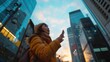 © Kanyakarn - A woman in a yellow jacket looks up at the skyline, capturing the beauty of urban architecture against a vibrant sunset.