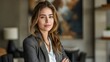 © VISUAL BACKGROUND - A woman in a business suit standing with her arms crossed