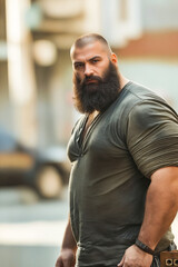 Canvas Print - A man with a long beard standing on a city street.